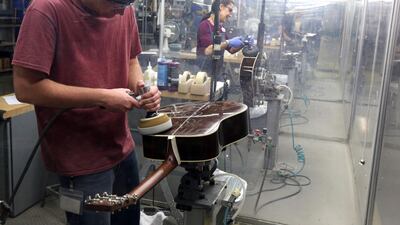 Workers buff guitars at CF Martin and Co. Fearful that parts of Africa and Asia were losing their rosewood forests to illegal loggers, international trade put regulations on hundreds of species of the trees. Among the hardest hit has been the music industry. Jacqueline Larma/AP