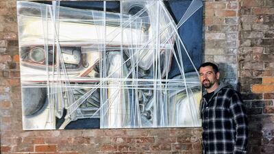 Jared Whipple stands next to a painting by Francis Hines that was found in a dumpster. AP