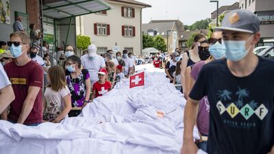 The pants, which weigh in at 700 kilograms, are carried in procession through Beromuenster during a folk festival. They were produced over eight months by Syrian tailor Xwendekar Kelesh. EPA