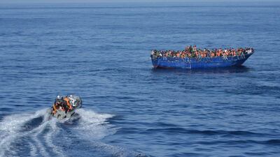 Spanish rescuers approach a boat carrying migrants off the coast of Libya. Spanish Ministry of Defense via AFP