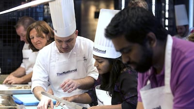 Pascal Sfara teaches the proper technique for preparation of a leader prawn to guest Yogi Karu during the #healthyliving cooking experience. Silvia Razgova / The National