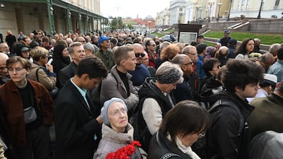 A woman holds flowers as she stands in line to file past the Nobel Peace Prize winner's coffin. AFP