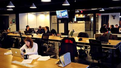 People work at tables inside of the WeWork co-operative co-working space in Washington DC. AFP
