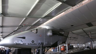Emirati men stand near the Solar Impulse 2, the first solar-powered plane to be able to fly for several days and nights. Karim Sahib / AFP
