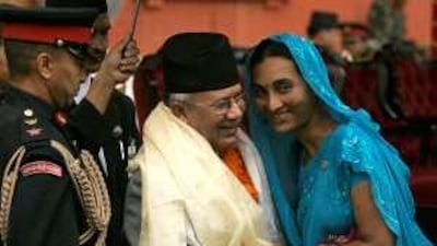 A well-wisher hugs Nepal's new prime minister, Madhav Kumar Nepal, centre, in Kathmandu yesterday.