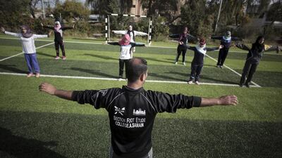 Palestinian coach Mahmoud Tafesh leads warm-up exercises.