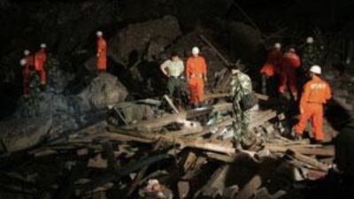 Rescue personnel search for survivors in a massive landslide in south-west China