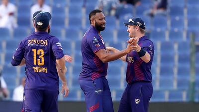 Kieron Pollard, centre, of Deccan Gladiators celebrates after taking the wicket of Qalandars' Tom Banton in Abu Dhabi on Tuesday. Pawan Singh / The National