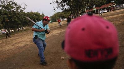 Men play baseball, or “king sport” as they call it in Nicaragua, in a neighbourhood of Managua, on January 13, 2016. Football is gaining enthusiasts in Nicaragua where baseball has been historically dominant but is now giving way to the new sport, analysts said. Inti Ocon / AFP