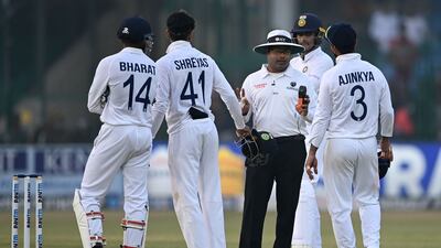 Field umpire (C) speaks with India's players on the fifth and final day of the first Test cricket match between India and New Zealand at the Green Park Stadium in Kanpur on November 29, 2021. (Photo by Sajjad HUSSAIN / AFP) / IMAGE RESTRICTED TO EDITORIAL USE - STRICTLY NO COMMERCIAL USE
