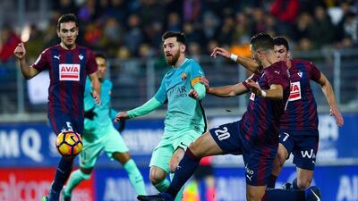 Lionel Messi cuts between two Eibar players. David Ramos / Getty Images