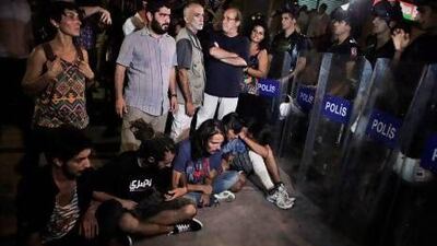Protesters wait before a Turkish riot police barricade near Taksim square in Istanbul on Tuesday. The police later fired tear gas to dispurse them.