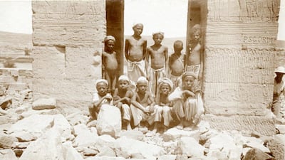 Ten local boys pose at the rock-strewn entrance of the temple of Dendur.
