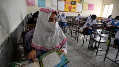 Children wearing facemasks attend a class at a school in Islamabad after the educational institutes reopened primary classes in the third and last phase nearly six months after the spread of the Covid-19 coronavirus. AFP