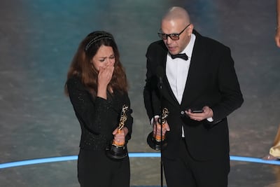 Shirin Sohani, left, and Hossein Molayemi receiving the Oscar for their animated film In the Shadow of the Cypress. AP
