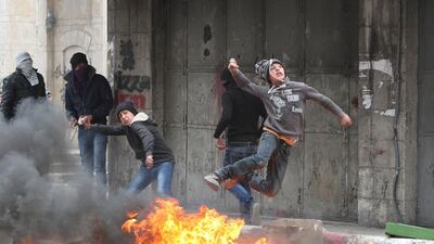 Palestinian stone throwers clash with Israeli security forces in the West Bank city of Hebron. Hazem Bader / AFP