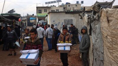 Displaced Syrians carry boxes from the UN World Food Programme before aid delivery was stopped, in the camp of Atma, Idlib, in rebel-held north-western Syria, on December 6. AFP