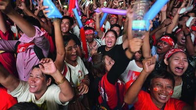 Supporters for Aung San Suu Kyi’s National League for Democracy shout with pleasure in front of the NLD headquarters in Yangon, while looking up at a large screen showing returns from Myanmar’s general election. The country’s election commission said the same day the opposition party has won 49 of the first 54 parliamentary seats. Kyodo