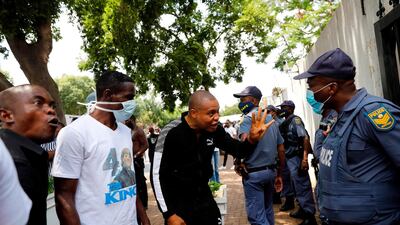 Nigerians based in South Africa react to South African Police Service (SAPS) officers as they protest outside the Nigerian embassy in Pretoria. AFP