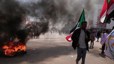 Protesters in Khartoum set tyres alight, filling the air with black smoke. AP