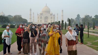 Foreign tourists wearing face masks visit the Taj Mahal under heavy smog conditions, in Agra, India. AFP