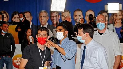 People watch election exit polls on screens at the Yesh Atid party campaign headquarters in Israel's Mediterranean coastal city of Tel Aviv. AFP
