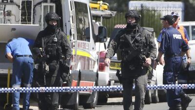 Australian tactical police officers walk on a cordoned off street of an industrial section of Ingleburn, in suburban Sydney. Rick Rycroft / AP Photo