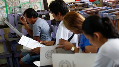 Filipinos fill out their ballots at an elementary school turned into a voting precinct in Quezon City, east of Manila, Philippines. EPA