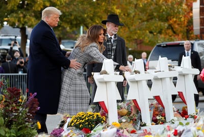President Donald Trump and first lady Melania Trump place stones on a memorial to shooting victims as they stand with Tree of Life Synagogue Rabbi Jeffrey Myers. Reuters