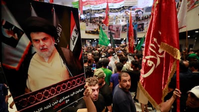 Supporters of Moqtada Al Sadr hold up a poster of the populist Iraqi cleric during a protest in parliament on August 2. AFP