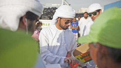 To celebrate Ramadan, a time of giving, a group of Emiratis gather outside a labour camp in Mussaffah to hand out iftar to workers. Among them is Hader Al Dhaheri, pictured handing out juice boxes to welcoming labourers. Lee Hoagland / The National