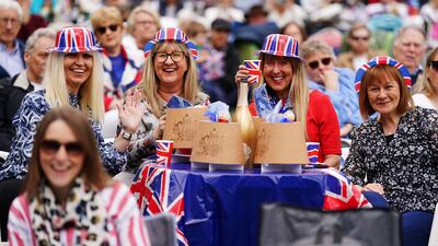 People watch the coronation of King Charles III and Queen Camilla on a big screen on the grounds of Hillsborough Castle, near Belfast. PA