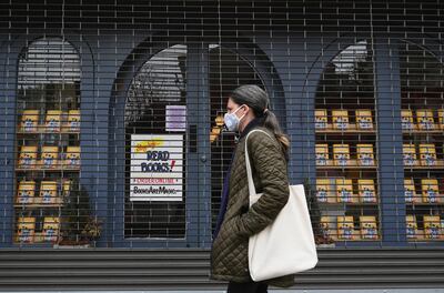 A woman walks by the closed "Books Are Magic" bookstore on May 5, 2020 in the Brooklyn borough of New York City. AFP