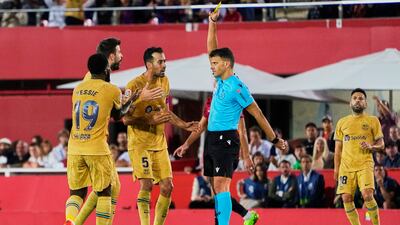 Referee Jesus Gil Manzano shows a yellow card to Barcelona defender Gerard Pique. Getty