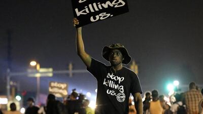 People walk through the streets after a standoff with police on August 18, during a protest for Michael Brown, who was killed by a police officer on August 9 in Ferguson, Mo. Brown's shooting has sparked more than a week of protests, riots and looting in the St. Louis suburb. Charlie Riedel / AP Photo