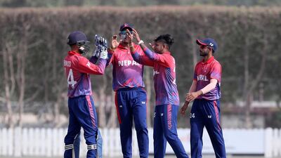 Sandeep Lamichhane, second right, celebrates after taking the wicket of UAE batsman Ghulam Shabber. Pawan Singh/The National