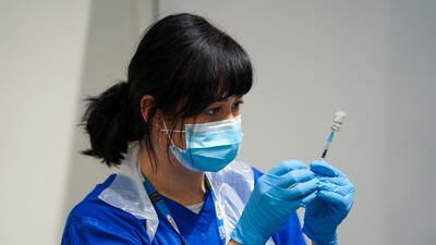 A member of staff prepares a Covid-19 vaccine at a pop-up vaccination centre at Westfield Stratford City shopping centre in east London. PA