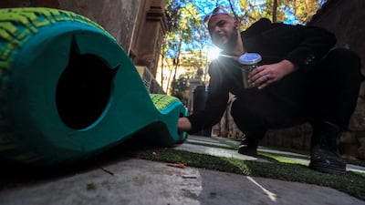 Ibrahim Abougendy, the company’s founder, puts cat food beside the shelters