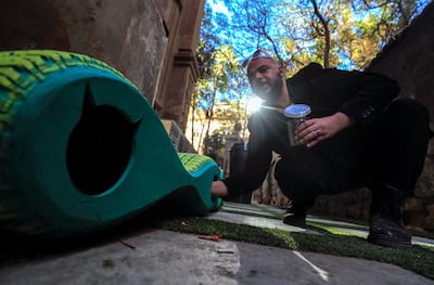 Ibrahim Abougendy, founder of the eco-friendly design studio Mobikya puts food for stray cats at his designed upcycled mobile shelters made out of old tyres to keep them warm during winter in Cairo, Egypt January 13, 2022. Picture taken January 13, 2022. REUTERS / Amr Abdallah Dalsh