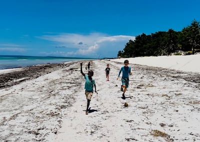 Charlie Tregoning racing along a beach in Zanzibar with his local friends. Photo: Harry Tregoning