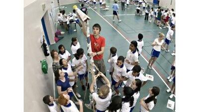 Readers of tomorrow: Matthew Kilsby, a senior, instals the last part of his team's newspaper tower during a contest in the induction sessions at Dubai College. His team's was the second-highest tower. Jeff Topping / The National