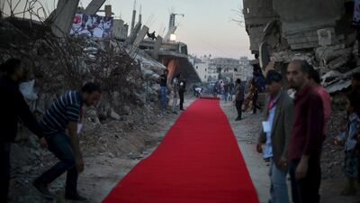 Palestinians place a red carpet between the ruins of houses for the first edition of the festival. The area was destroyed by Israeli shelling during a 50-day war in 2014. Reuters.