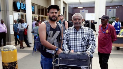 Ahmed Khalid, left, with his father after arriving at Jomo Kenyatta International Airport in Nairobi. Reuters