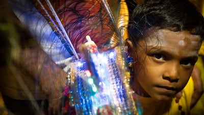 A Hindu boy carries a Kavadi offering cages in a procession during the Thaipusam festival at Batu Caves, outskirts of Kuala Lumpur. AP Photo