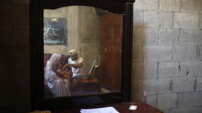Mohammed is reflected in a mirror as he plays with his daughter.