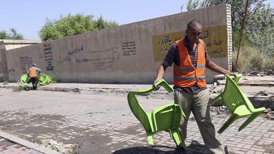 Iraqi municipality workers clean the scene of a suicide attack in Baghdad's western Eskan neighbourhood, Iraq, Sunday, Sept. 25, 2016. A suicide bomber killed several people who were setting up tents on Sunday ahead of a major Shiite religious observance next month, officials said. (AP Photo/Hadi Mizban)