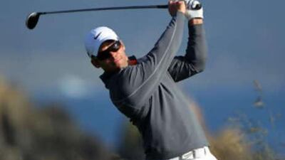 Paul Casey of England watches his tee shot on the 18th hole during the first round.
