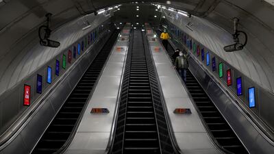Only a few people use the escalator at a tube station in London. AP Photo