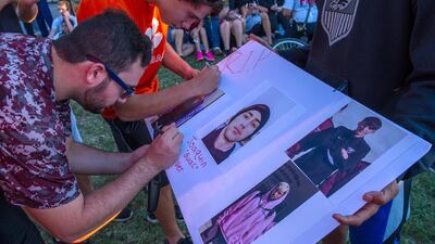 epa06530231 Students sign a poster with photos of Joaquin Oliver, one of the victims of a school shooting. Giorgio Viera / EPA