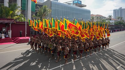 Sri Lankan government soldiers march carrying national flags. AP Photo